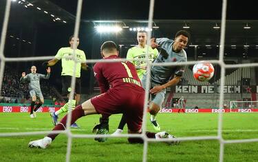 dpatop - 18 January 2022, Hamburg: Soccer: DFB-Pokal, FC St. Pauli - Borussia Dortmund, Round of 16, Millerntor-Stadion. 1:0 for St. Pauli through Etienne Amenyido (r). Goalkeeper Dennis Smarsch cannot prevent it. (IMPORTANT NOTE: In accordance with the regulations of the DFL Deutsche FuÃ ball Liga and the DFB Deutscher FuÃ ball-Bund, it is prohibited to use or have used photographs taken in the stadium and/or of the match in the form of sequence pictures and/or video-like photo series). Photo: Christian Charisius/dpa (Photo by Christian Charisius/picture alliance via Getty Images)