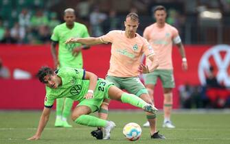WOLFSBURG, GERMANY - AUGUST 06: Jonas Wind of VfL Wolfsburg and Christian Gross of Werder Bremen battle for possession during the Bundesliga match between VfL Wolfsburg and SV Werder Bremen at Volkswagen Arena on August 06, 2022 in Wolfsburg, Germany. (Photo by Cathrin Mueller/Getty Images)