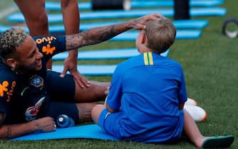 Brazil's forward Neymar (L) jokes with his son Davi Lucca during a training session at the Yug-Sport Stadium in Sochi on June 29, 2018 during the Russia 2018 World Cup football tournament. (Photo by Adrian DENNIS / AFP)        (Photo credit should read ADRIAN DENNIS/AFP via Getty Images)