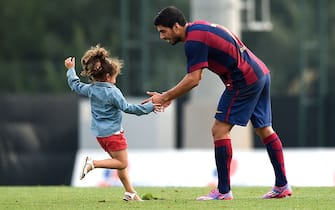 BARCELONA, SPAIN - SEPTEMBER 24:  Luis Suarez of FC Barcelona hugs to his daughter Delfina Suarez after a friendly match between FC Barcelona B and Indonesia U19 at Ciutat Esportiva on September 24, 2014 in Barcelona, Spain.  (Photo by David Ramos/Getty Images)
