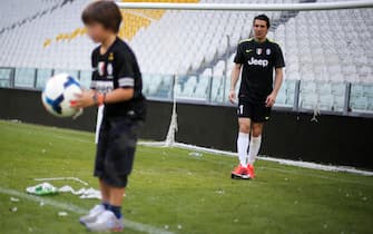 Juventus' goalkeeper Gianluigi Buffon plays with his son after the Italian Serie A football match Juventus vs Cagliari and the trophy ceremony of the "scudetto" on May 18, 2014 in Juventus Stadium in Turin. Juventus won their third consecutive "scudetto". AFP PHOTO / MARCO BERTORELLO / AFP PHOTO / Marco BERTORELLO        (Photo credit should read MARCO BERTORELLO/AFP via Getty Images)
