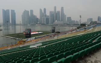 The Singapore waterfront stadium and Formula One racetrack seen in the foreground and the Marina Bay skyline is blanketed by haze on September 18, 2014 as the city-state reached the final stage of preparations for the weekend's Singapore Formula One Grand Prix night race. Singapore's National Environment Agency (NEA) said the pollutant standards index (PSI) stood at 106 on afternoon of September 18, a level considered as unhealthy. Singapore authorities said the smog came from forest fires raging in the neighbouring Indonesian island of Sumatra and in Kalimantan on Borneo. The Singapore Grand Prix will take place on September 21.  AFP PHOTO / ROMEO GACAD        (Photo credit should read ROMEO GACAD/AFP via Getty Images)