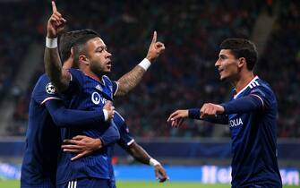 Lyon's Dutch forward Memphis Depay (C) celebrates scoring the opening goal with Lyon's French midfielder Houssem Aouar (R) and Lyon's French midfielder Martin Terrier (L) during the UEFA Champions League Group G football match RB Leipzig v Olympique Lyonnais (OL) in Leipzig, eastern Germany, on October 2, 2019. (Photo by Ronny Hartmann / AFP) (Photo by RONNY HARTMANN/AFP via Getty Images)