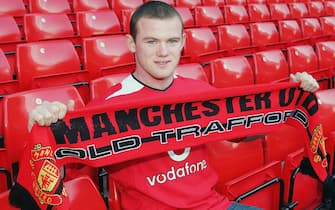 MANCHESTER, ENGLAND - AUGUST 31:  Wayne Rooney poses for photographs with a Manchester United scarf after signing for Manchester United on August 31, 2004 at Old Trafford in Manchester, England. (Photo by John Peters/Manchester United via Getty Images)