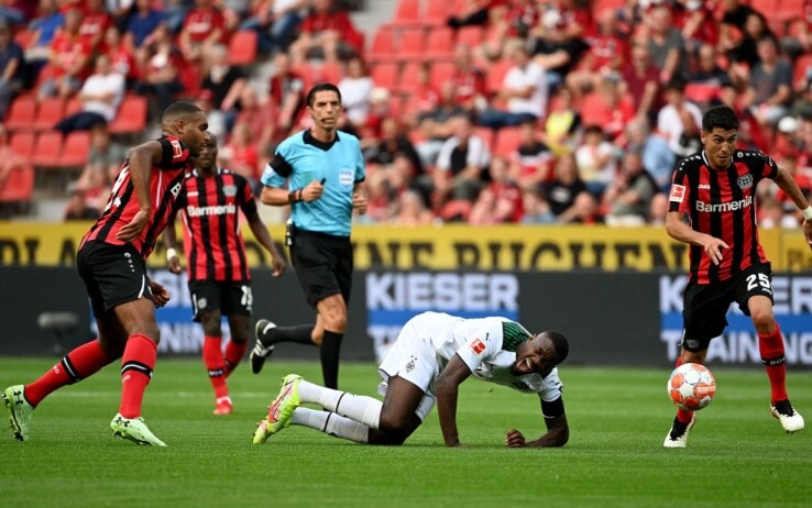 Thuram cade dopo essere stato colpito da Tah del Bayer Leverkusen