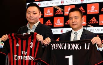 Head of Rossoneri Sport Investment Lux, Chinese businessman and new owner of the AC Milan football club, Yonghong Li (R) poses with Rossoneri Sport Investment Lux representative David Han Li (L) during a press conference on April 14, 2017 in Milan.

Serie A giants AC Milan were sold to Rossoneri Sport Investment Lux yesterday in a deal which sees the Chinese-led consortium take a 99.9% stake in the club. The seven-time European champions who are Italy's most succcessful club in international competition, have been owned by former three-time Italy prime minister Silvio Berlusconi since 1986. A joint statement by AC Milan's holding company Fininvest and Rossoneri Sport Investment Lux said on April 13, 2017 : "Today Fininvest has completed the sale of the entire stake owned in AC Milan - equal to 99.93% - to Rossoneri Sport Investment Lux."
 / AFP PHOTO / MIGUEL MEDINA        (Photo credit should read MIGUEL MEDINA/AFP via Getty Images)
