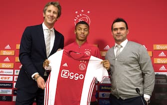 New recruit Brazilian forward David Neres Campos (C) poses with Ajax Amsterdam football club's marketing directors Edwin van der Sar (L) and Marc Overmars (R) during a presentation in Amsterdam on February 17, 2017.  / AFP PHOTO / ANP / Olaf KRAAK / Netherlands OUT        (Photo credit should read OLAF KRAAK/AFP via Getty Images)