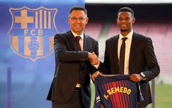 Barcelona's new Portuguese player Nelson Semedo (R) poses with his new jersey as he shakes hands with Barcelona's president Josep Maria Bartomeu during his official presentation, after signing his new contract with the Catalan club at the Camp Nou stadium in Barcelona on July 14, 2017. / AFP PHOTO / LLUIS GENE        (Photo credit should read LLUIS GENE/AFP via Getty Images)