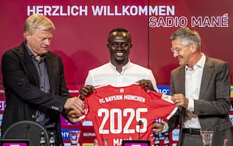epa10027969 Sadio Mane (C) poses with the team's shirt with Bayern Munich CEO Oliver Kahn (L) and Bayern Munich Chairman of the Supervisory Board Herbert Hainer at a press conference during his presentation as a new signing for Bayern Munich, Munich, 22 June 2022. The Senegalese international left Liverpool FC after six years to join the German champions on a three-year contract.  EPA/MARTIN DIVISEK