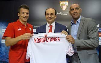 epa04854404 Ukranian striker Yehven Konoplyanka (L) poses with Sevilla FC's president Jose Castro (c) and Sports Manager Ramon Rodriguez 'Monchi' (R) during his presentation as new player of the team during an act held at  Ramon Sanchez Pizjuan's stadium in Seville, Andalusia, Spain on 20 July 2015. Konoplyanka, who comes from Dnipro, has signed for the next four seasons.  EPA/JULIO MUNOZ