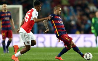 FC Barcelona Brazilian defense Dani Alves (R) and Arsenal FC Alex Iwobi fight for the ball during a Champions League round 16 match held at Camp Nou stadium in Barcelona, Catalonia, Spain, 16 March 2016. EFE/Toni Albir 