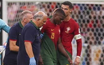 epa10335237 Cristiano Ronaldo (C) kisses Nuno Mendes of Portugal who leaves the pitch after being injured during the FIFA World Cup 2022 group H soccer match between Portugal and Uruguay at Lusail Stadium in Lusail, Qatar, 28 November 2022.  EPA/JOSE SENA GOULAO