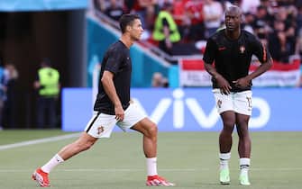 epa09273407 Cristiano Ronaldo (L) of Portugal and Danilo Pereira of Portugal warm up prior to the UEFA EURO 2020 group F preliminary round soccer match between Hungary and Portugal in Budapest, Hungary, 15 June 2021.  EPA/Bernadett Szabo / POOL (RESTRICTIONS: For editorial news reporting purposes only. Images must appear as still images and must not emulate match action video footage. Photographs published in online publications shall have an interval of at least 20 seconds between the posting.)