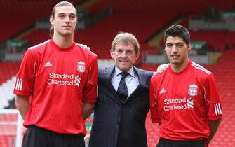 epa02562364 Liverpool FC head coach Kenny Dalglish (C) poses for photographers with the club's new signings Uruguayan striker Luis Suarez (R) and English Andy Carroll (L) during their presentation at the Anfield stadium in Liverpool, north west Britain, 03 February 2011. Suarez joined Liverpool FC on January 31 from Dutch soccer club Ajax for 22.7 million pounds (26.7 million euro). Forward position player Carroll joined Liverpool from Newcastle United for 35 million pounds (41 million euro) although he is unfit to play due to an injured thigh.  EPA/LINDSEY PARNABY NO ONLINE/INTERNET USE WITHOUT A LICENSE FROM THE FOOTBALL DATA CO.LTD.