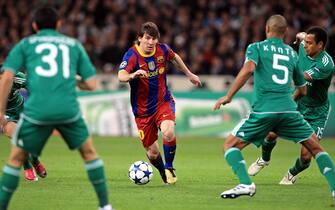 epa02465403 Barcelona's Lionel Messi (C) vies for the ball with Panathinaikos' Cedric Kante (R) during the Champions League group D soccer match between Panathinaikos FC and FC Barcelona in Athens, Greece, 24 November 2010.  EPA/ORESTIS PANAGIOTOU