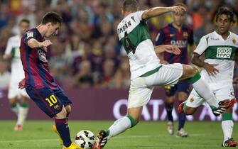 FC Barcelona's Argentinian striker Lionel Messi (L) fights for the ball with defender David Lomban (R) of Elche during their Primera Division soccer match played at Camp Nou stadium in Barcelona, Catalonia, Spain on 24 August 2014. EFE/Alejandro Garcia 