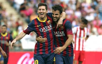 epa03887749 FC Barcelona's Lionel Messi (L) celebrates with teammate Cesc Fabregas (R) after scoring the opening goal against UD Almeria during the Spanish Liga Primera Division soccer match between Almeria and FC Barcelona at Juegos Mediterraneos stadium, in Almeria, Spain, 28 September 2013.  EPA/CARLOS BARBA
