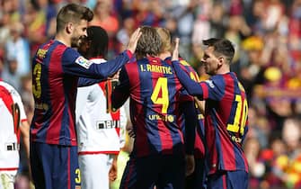 FC Barcelona's Lionel Messi (R) celebrates with his teammates Gerard Pique (L) and Ivan Rakitic (C) after scoring a goal against Rayo Vallecano during a Spanish Primera Division league match at Camp Nou stadium, in Barcelona, northeastern Spain, 08 March 2015. FC Barcelona won 6-1. EFE/Toni Albir