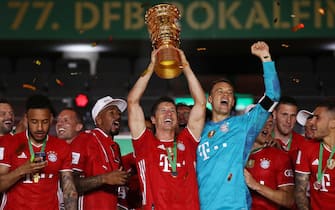 epa08527734 Bayern Munich's Robert Lewandowski (C) lifts the trophy as his teammates celebrate after winning the German DFB Cup final between Bayer 04 Leverkusen and FC Bayern Munich at Olympic Stadium in Berlin, Germany, 04 July 2020.  EPA/ALEXANDER HASSENSTEIN / POOL CONDITIONS - ATTENTION: The DFB regulations prohibit any use of photographs as image sequences and/or quasi-video.