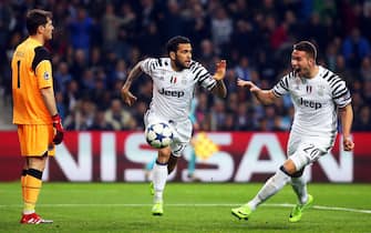 epa05809465 Juventus' Dani Alves (C) celebrates with his teammate Marko Pjaca (R) after scoring the 2-0 lead against FC Porto's goalkeeper Iker Casillas (L) during the UEFA Champions League round of 16, first leg soccer match between FC Porto and Juventus FC at Dragao stadium in Porto, Portugal, 22 February 2017.  EPA/JOSE COELHO