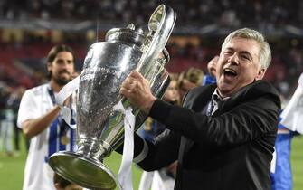 Real Madrid's Italian coach Carlo Ancelotti celebrates their victory with the trophy at the end of the UEFA Champions League Final Real Madrid vs Atletico de Madrid at Luz stadium in Lisbon, on May 24, 2014. Real Madrid won 4-1.  AFP PHOTO/ FRANCK FIFE        (Photo credit should read FRANCK FIFE/AFP/Getty Images)