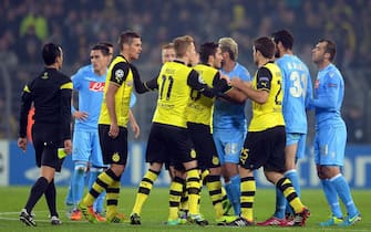 epa03966492 Dortmund players (yellow) argue with Napoli players (blue) during the UEFA Champions League group F soccer match between Borussia Dortmund and SSC Napoli in Dortmund, Germany, 26 November 2013.  EPA/FEDERICO GAMBARINI