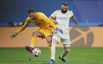 MADRID, SPAIN - MARCH 09: Karim Benzema (R) of Real Madrid CF tackles goalkeeper Gianluigi Donnarumma (L) of Paris Saint-Germain during the UEFA Champions League Round Of Sixteen Leg Two match between Real Madrid and Paris Saint-Germain at Estadio Santiago Bernabeu on March 09, 2022 in Madrid, Spain. (Photo by Gonzalo Arroyo Moreno/Getty Images)