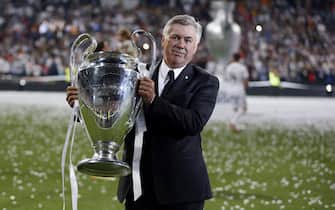 epa04225772 Real Madrid's Italian head coach Carlo Ancelotti holds the winner trophy during an event to celebrate their win in the UEFA Champions League held at Santiago Bernabeu stadium in Madrid, Spain on 25 May 2014. Real Madrid become European champions for the 10th time by beating city rivals Atletico Madrid 4-1 after extra time in Lisbon on 24 May.  EPA/Javier Lizon