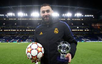 LONDON, ENGLAND - APRIL 06: Karim Benzema of Real Madrid poses for a photo with their PlayStation Player Of The Match Award and the match ball after their hat trick during sides victory in the UEFA Champions League Quarter Final Leg One match between Chelsea FC and Real Madrid at Stamford Bridge on April 06, 2022 in London, England. (Photo by Matthew Lewis - UEFA/UEFA via Getty Images)