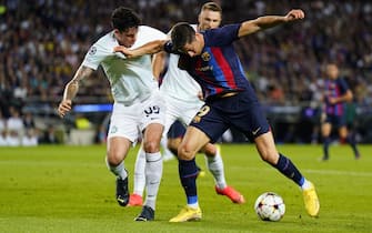 epa10239372 FC Barcelona's Robert Lewandowski (R) in action against FC Internazionale Milano's Alessandro Bastoni (L) during the UEFA Champions League Group C soccer match between FC Barcelona and FC Internazionale Milano, in Barcelona, eastern Spain, 12 October 2022.  EPA/Siu Wu