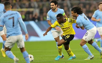 epa10265729 Youssoufa Moukoko (C) of Dortmund in action against Nathan Ake of Manchester City during the UEFA Champions League group G match between Borussia Dortmund and Manchester City in Dortmund, Germany, 25 October 2022.  EPA/FRIEDEMANN VOGEL