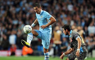 epa02917076 Manchester City's Aleksandar Kolarov (L) vies for the ball with Napoli's Blerim Dzemaili (R) during the UEFA Champions League soccer match between Manchester City and SSC Napoli in Manchester, Britain, 14 September 2011. The match ended 1-1.  EPA/ROBIN PARKER
