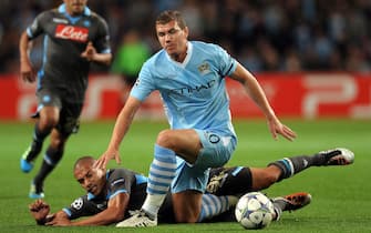 epa02916849 Manchester City's Edin Dzeko (C) is tackled by Napoli's Gokhan Inler (bottom) during the UEFA Champions League soccer match between Manchester City and SSC Napoli in Manchester, Britain, 14 September 2011.  EPA/ROBIN PARKER