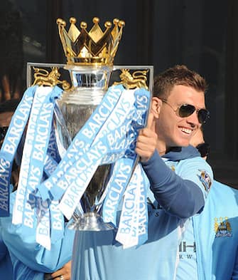 epa03219185 Manchester City's Edin Dzeko lifts the Premier League trophy  from a stage in Saint Peters square in the centre of Manchester, which they won after the completion of the soccer match with Queens Park Rangers in Manchester, Britain, 14 May 2012.  EPA/PETER POWELL