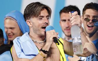 Manchester City's Jack Grealish with a bottle of vodka on stage during the Treble Parade in Manchester. Manchester City completed the treble (Champions League, Premier League and FA Cup) after a 1-0 victory over Inter Milan in Istanbul secured them Champions League glory. Picture date: Monday June 12, 2023.
