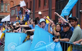 Fans waving flags ahead of the Treble Parade in Manchester. Manchester City completed the treble (Champions League, Premier League and FA Cup) after a 1-0 victory over Inter Milan in Istanbul secured them Champions League glory. Picture date: Monday June 12, 2023.