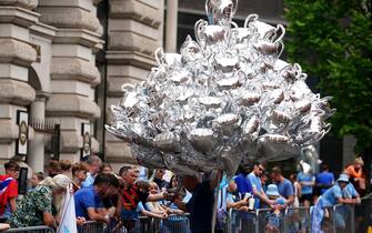 A street vendor with trophy balloons ahead of the Treble Parade in Manchester. Manchester City completed the treble (Champions League, Premier League and FA Cup) after a 1-0 victory over Inter Milan in Istanbul secured them Champions League glory. Picture date: Monday June 12, 2023.