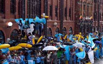 Manchester City fans take shelter from the rain ahead of the Treble Parade in Manchester. Manchester City completed the treble (Champions League, Premier League and FA Cup) after a 1-0 victory over Inter Milan in Istanbul secured them Champions League glory. Picture date: Monday June 12, 2023.