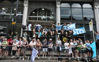 epa10687306 Manchester City fans gather as they wait for the team to start the open top bus parade to celebrate winning the treble, winning the Champions League as well as the Premier League and FA Cup in Manchester, Britain, 12 June 2023.  EPA/Adam Vaughan