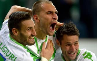epa04987858 Wolfsburgs Bas Dost (c) celebrates his 1:0 with teammates Daniel Caligiuri (l) and Christian Traesch during the UEFA Champions league Group B match between VfL Wolfsburg and PSV Eindhoven in Wolfsburg, Germany, 21 October 2015.  EPA/Peter Steffen