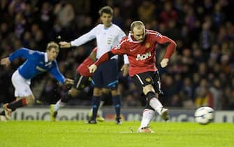 epa02465561 Wayne Rooney (R) of Manchester United scores the winning goal from the penalty spot against Glasgow Rangers during the UEFA Champions League group C soccer match at Ibrox Stadium in Glasgow, Scotland, 24 November 2010. ManU won 1-0.  EPA/BRIAN STEWART