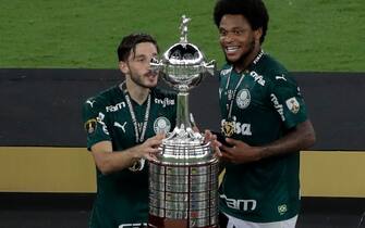 Palmeiras' Uruguayan Matias Vina (L) and teammate Luiz Adriano touch the trophy after winning the Copa Libertadores football tournament by defeating Santos in the all-Brazilian final match at Maracana Stadium in Rio de Janeiro, Brazil, on January 30, 2021. (Photo by Silvia Izquierdo / POOL / AFP) (Photo by SILVIA IZQUIERDO/POOL/AFP via Getty Images)