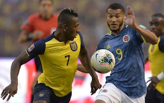 TOPSHOT - Ecuador's Pervis Estupinan (L) and Colombia's Luis Javier Suarez vie for the ball during their closed-door 2022 FIFA World Cup South American qualifier football match at the Rodrigo Paz Delgado Stadium in Quito on November 17, 2020. (Photo by RODRIGO BUENDIA / POOL / AFP) (Photo by RODRIGO BUENDIA/POOL/AFP via Getty Images)