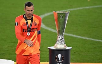 epa08617454 Inter goalkeeper Samir Handanovic walks past the trophy after picking up his runner-up medal after the UEFA Europa League final match between Sevilla FC and Inter Milan in Cologne, Germany 21 August 2020. Sevilla won 3-2.  EPA/Ina Fassbender / POOL