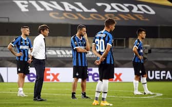 epa08617439 Inter's head coach Antonio Conte (2-L) and his players show their dejection after losing the UEFA Europa League final match between Sevilla FC and Inter Milan in Cologne, Germany, 21 August 2020. Sevilla won 3-2.  EPA/Wolfgang Rattay / POOL