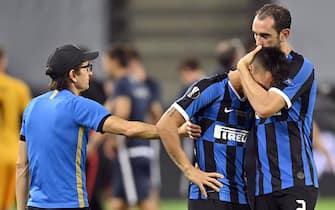 epa08617326 Diego Godin of Inter (R) comforts teammate Lautaro Martinez after the UEFA Europa League final match between Sevilla FC and Inter Milan in Cologne, Germany 21 August 2020.  EPA/Martin Meissner / POOL