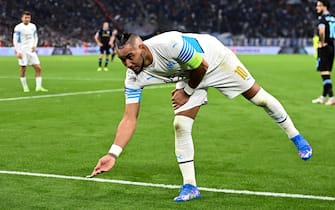 epa09564872 Dimitri PAYET of Olympique Marseille  picks up a lighter which was thrown on the pitch during the UEFA Europa League Group E soccer match between Olympique Marseille and SS Lazio at the Velodrome Stadium in Marseille, southern France, 04 November 2021.  EPA/ALEXANDRE DIMOU