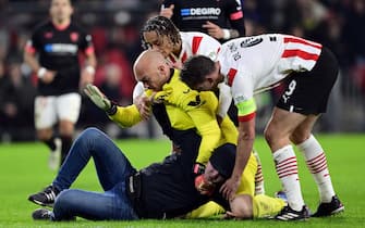 epa10486473 A pitch invader assaults Sevilla FC goalkeeper Marko Dmitrovic during the UEFA Europa league play-off soccer match between PSV Eindhoven and Sevilla FC, in Eindhoven, Netherlands, 23 February 2023.  EPA/OLAF KRAAK