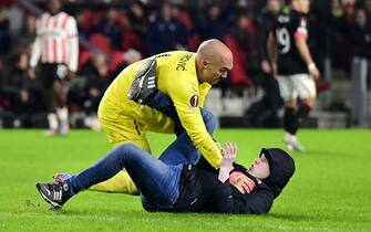 EINDHOVEN - A PSV supporter of PSV on the pitch with goalkeeper Marko Dmitrovic of Sevilla during the UEFA Europa league play-off match between PSV Eindhoven and Sevilla FC at Phillips stadium on February 23, 2023 in Eindhoven, Netherlands. ANP OLAF KRAAK /ANP/Sipa USA