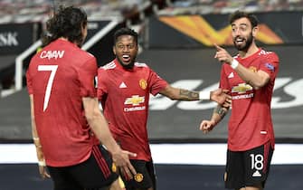 epa09168440 Bruno Fernandes (R) of Manchester United celebrates with teammates after scoring the 1-0 lead during the UEFA Europa League semi final, first leg soccer match between Manchester United and AS Roma at Old Trafford in Manchester, Britain, 29 April 2021.  EPA/PETER POWELL